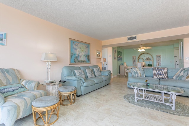 living room with a textured ceiling and ceiling fan