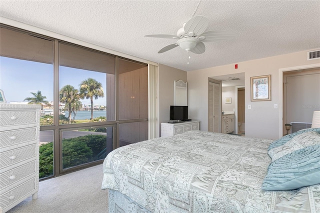 carpeted bedroom featuring ceiling fan, floor to ceiling windows, and a textured ceiling