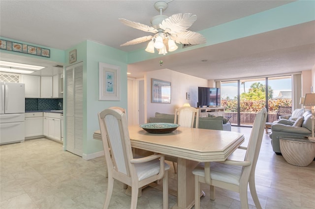 dining space with floor to ceiling windows, a textured ceiling, and ceiling fan