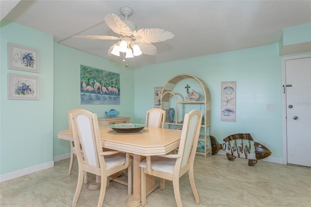 dining space featuring ceiling fan and a textured ceiling