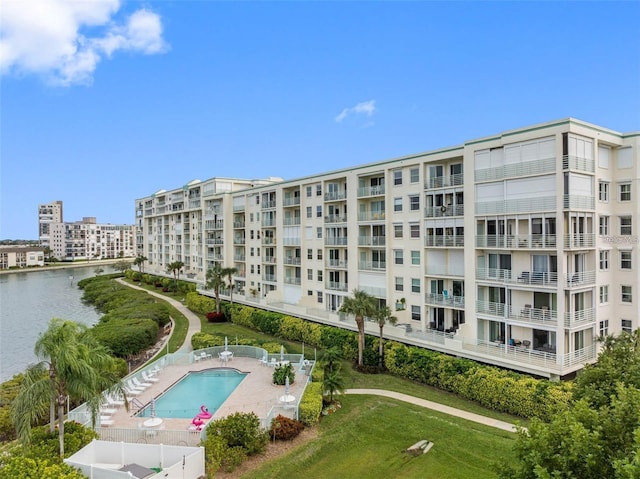 view of building exterior featuring a water view and a community pool