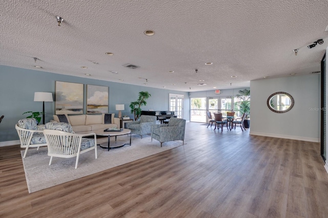 living room featuring light hardwood / wood-style flooring and a textured ceiling