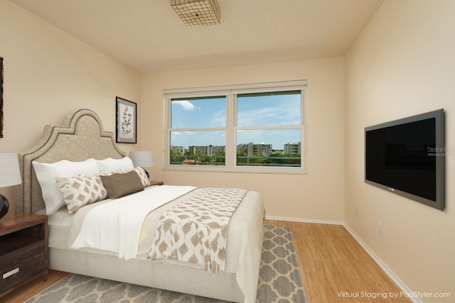 bedroom featuring light hardwood / wood-style floors and a textured ceiling