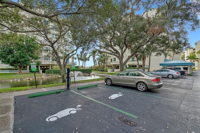 view of car parking featuring a water view