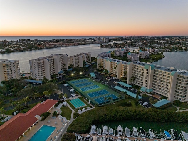 aerial view at dusk featuring a water view