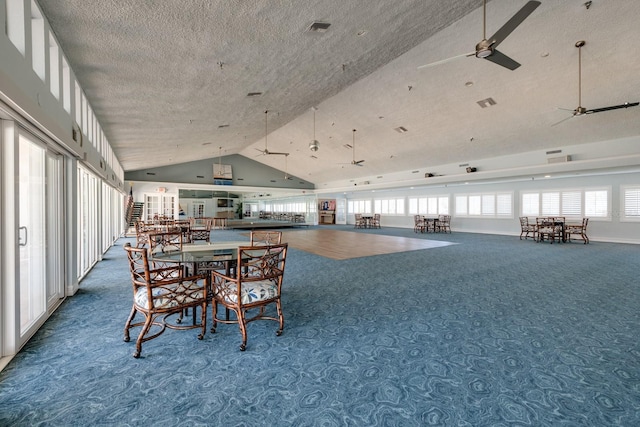 carpeted dining area featuring ceiling fan, high vaulted ceiling, and a textured ceiling