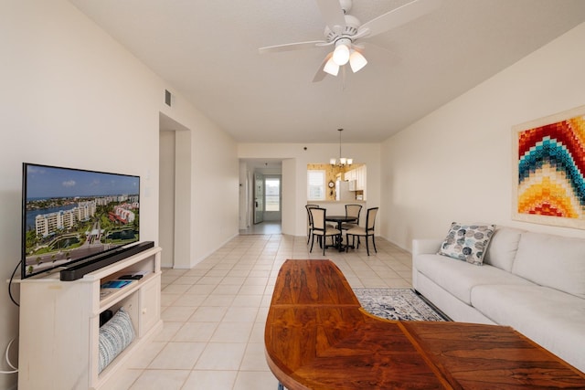 living room with light tile patterned flooring and ceiling fan with notable chandelier