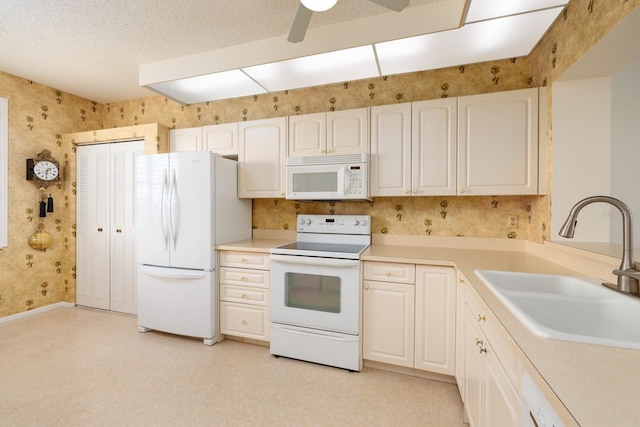 kitchen featuring white appliances, sink, white cabinetry, a textured ceiling, and ceiling fan