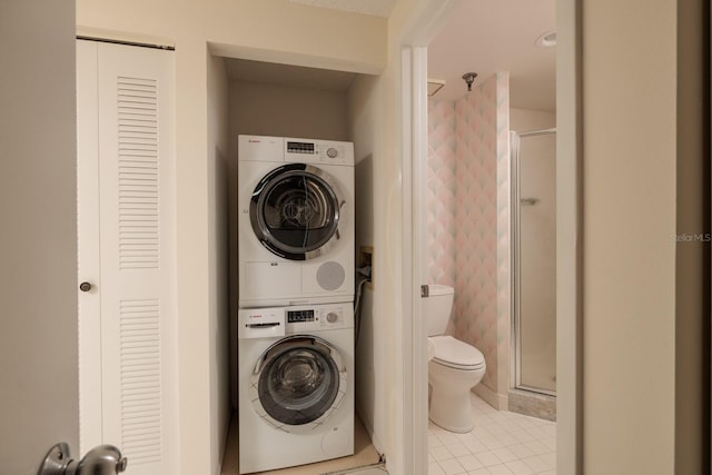 washroom with light tile patterned floors and stacked washing maching and dryer