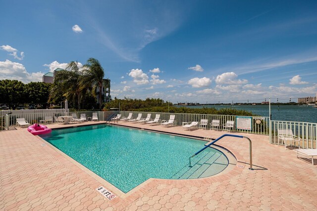 view of pool featuring a patio and a water view