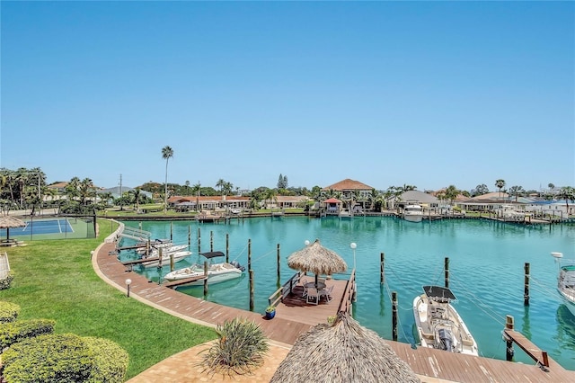 view of dock with a lawn and a water view