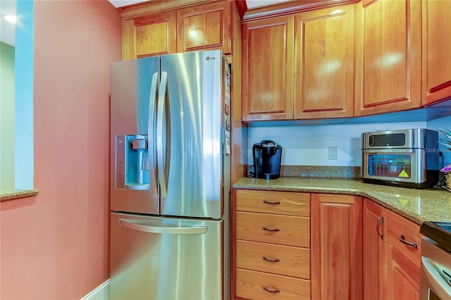 kitchen featuring light stone countertops and stainless steel appliances