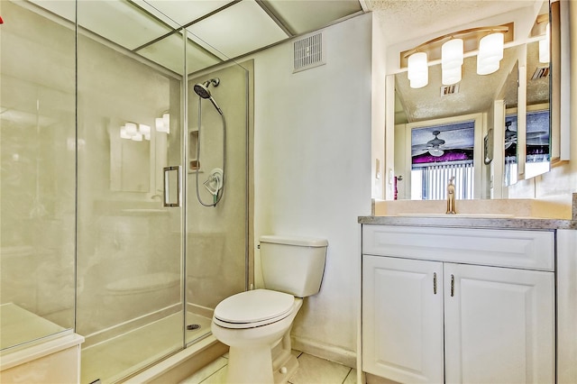 bathroom featuring tile patterned flooring, vanity, toilet, and walk in shower