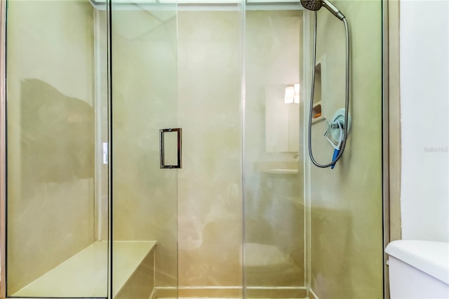 bathroom featuring toilet and an enclosed shower