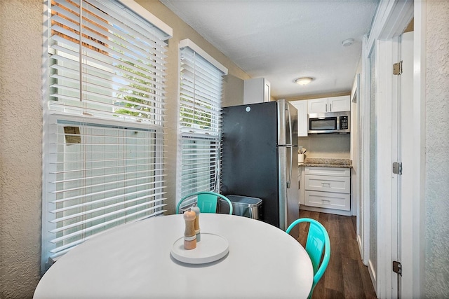 dining space featuring dark hardwood / wood-style flooring and a textured ceiling