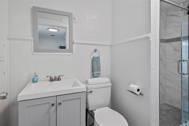 bathroom with vanity, a shower with shower door, and toilet