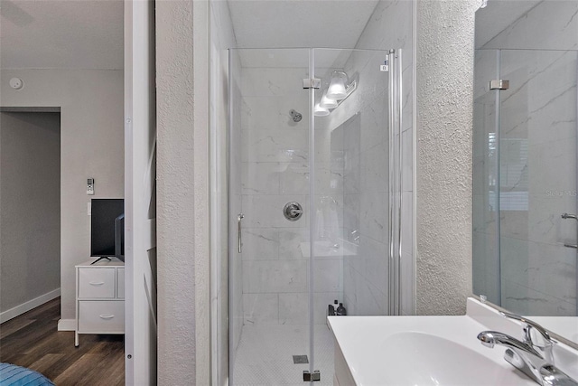 bathroom featuring vanity, wood-type flooring, and a shower with door