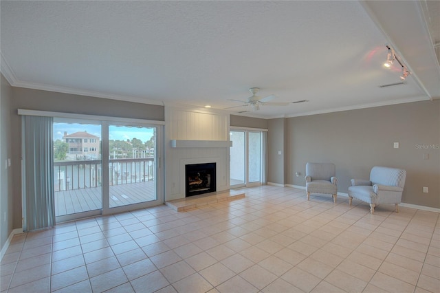 unfurnished living room featuring ceiling fan, a large fireplace, light tile patterned flooring, crown molding, and track lighting