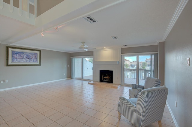 living room featuring light tile patterned floors, ceiling fan, a large fireplace, and crown molding