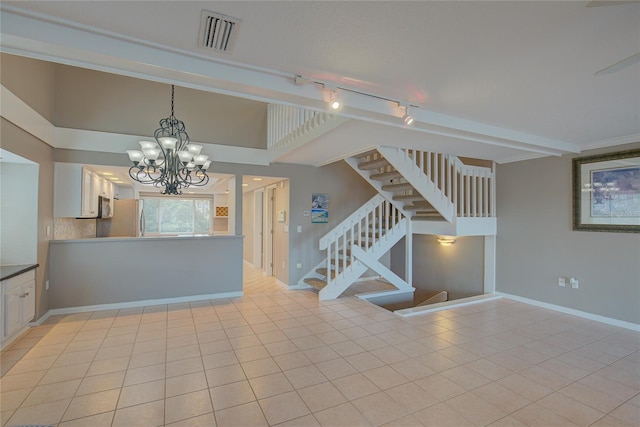 unfurnished room featuring light tile patterned floors, a notable chandelier, and rail lighting