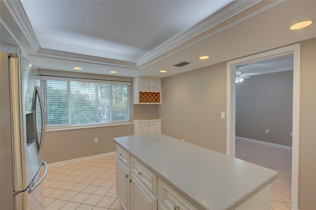 kitchen with stainless steel refrigerator with ice dispenser, ornamental molding, light tile patterned flooring, and a center island