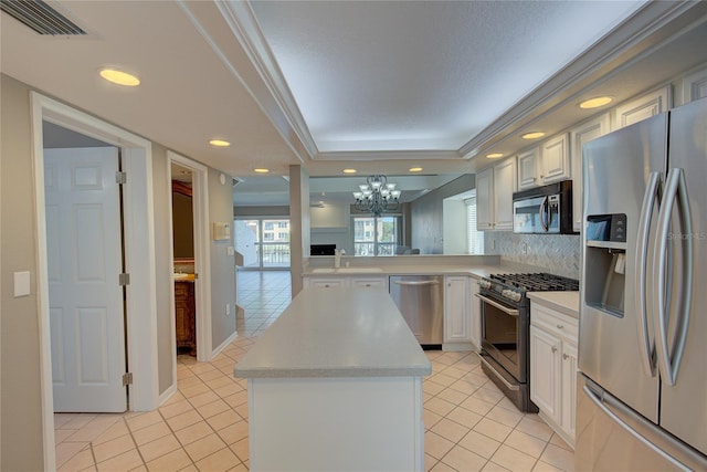 kitchen featuring visible vents, a kitchen island, light countertops, light tile patterned floors, and stainless steel appliances