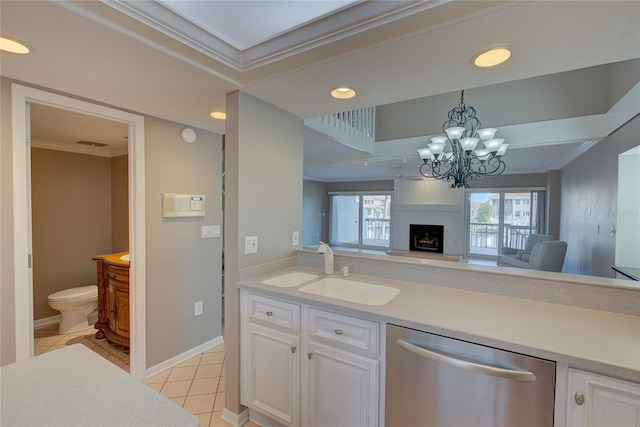 kitchen with light tile patterned floors, white cabinetry, a fireplace, dishwasher, and sink