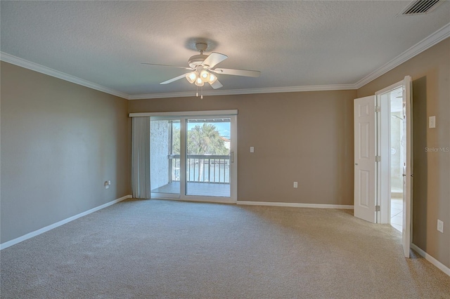 empty room with baseboards, visible vents, a textured ceiling, crown molding, and light carpet