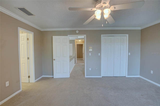 unfurnished bedroom with light carpet, ceiling fan, a closet, and crown molding