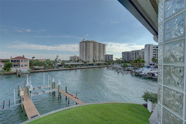 view of dock featuring a water view, boat lift, and a city view