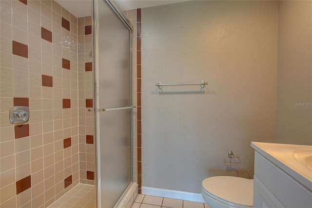 bathroom featuring vanity, tile patterned floors, baseboards, and a stall shower