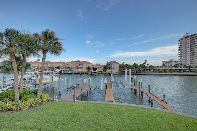 view of dock featuring boat lift, a lawn, and a water view