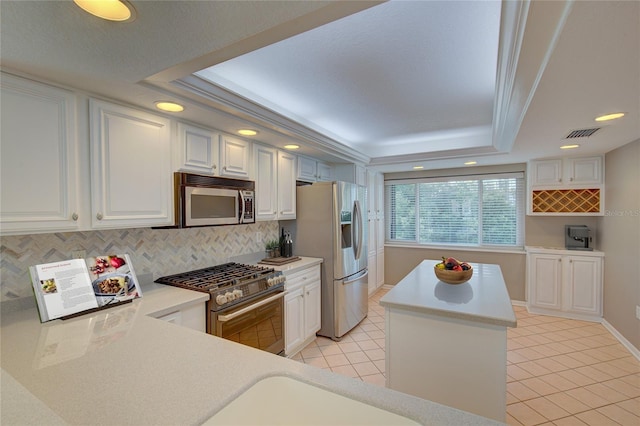 kitchen with visible vents, light countertops, a tray ceiling, appliances with stainless steel finishes, and light tile patterned flooring