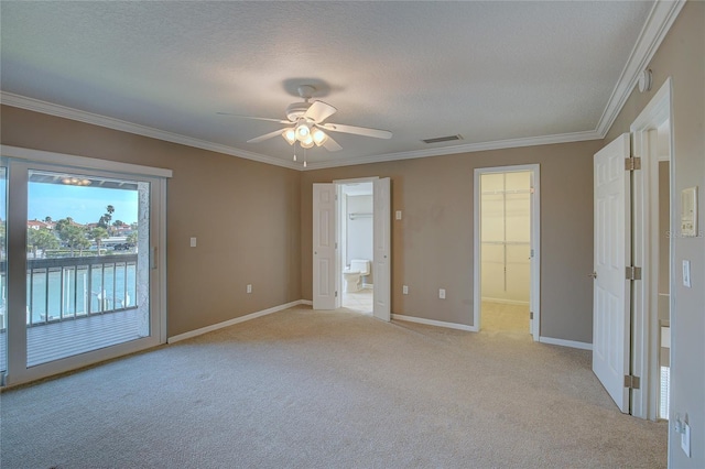 unfurnished bedroom featuring baseboards, visible vents, light carpet, crown molding, and access to outside