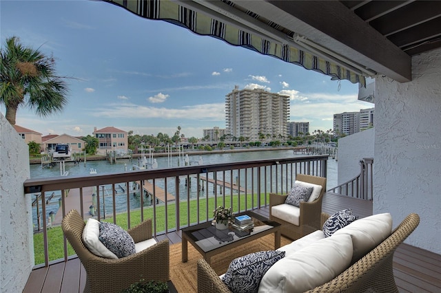 balcony with a city view, an outdoor living space, and a water view