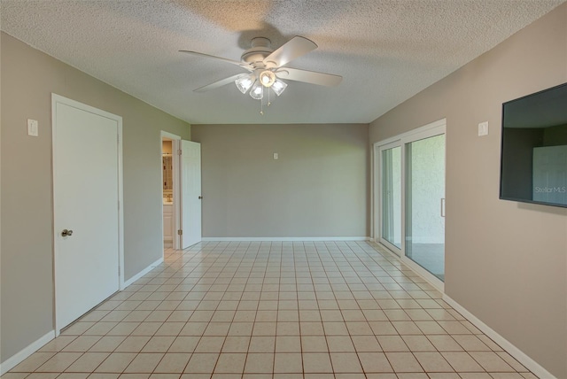 empty room with light tile patterned flooring, baseboards, a textured ceiling, and ceiling fan