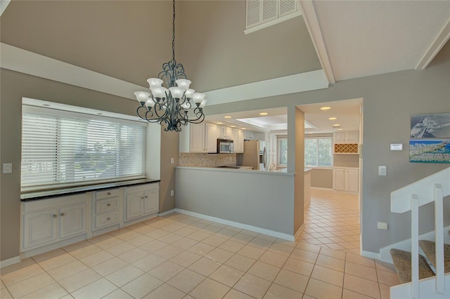 kitchen featuring visible vents, backsplash, stainless steel appliances, a peninsula, and light tile patterned floors