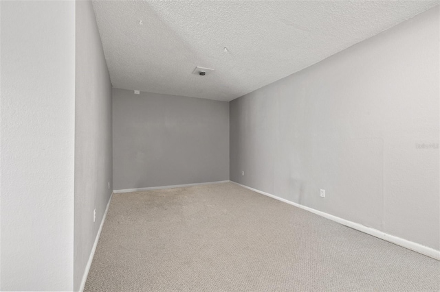 empty room with carpet floors and a textured ceiling