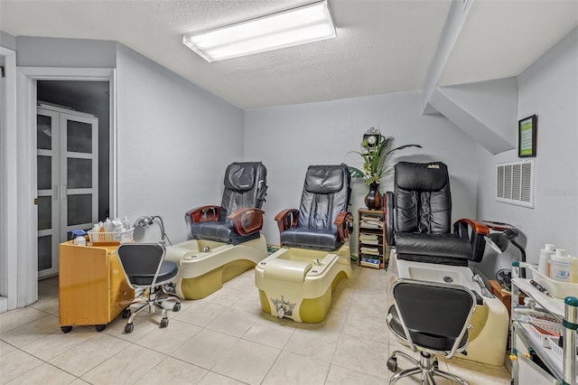 interior space with light tile patterned flooring and a textured ceiling