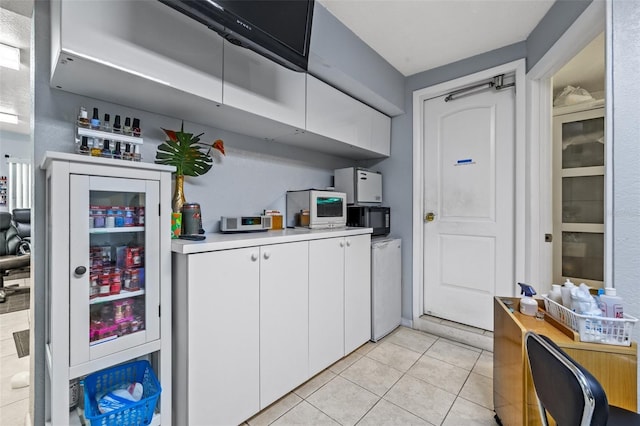 kitchen with white cabinetry and light tile patterned flooring