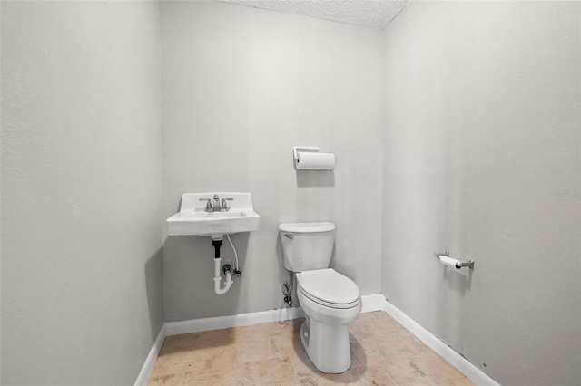 bathroom with a textured ceiling and toilet