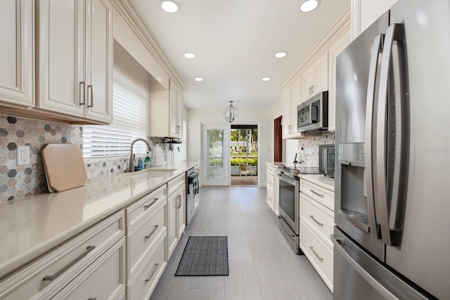 kitchen with decorative backsplash, sink, white cabinets, and stainless steel appliances