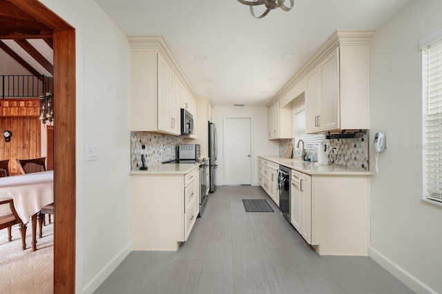 kitchen with appliances with stainless steel finishes, tasteful backsplash, white cabinetry, and sink