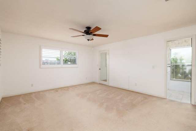 empty room featuring plenty of natural light, ceiling fan, and light colored carpet