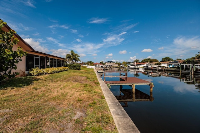 view of dock with a water view and a yard