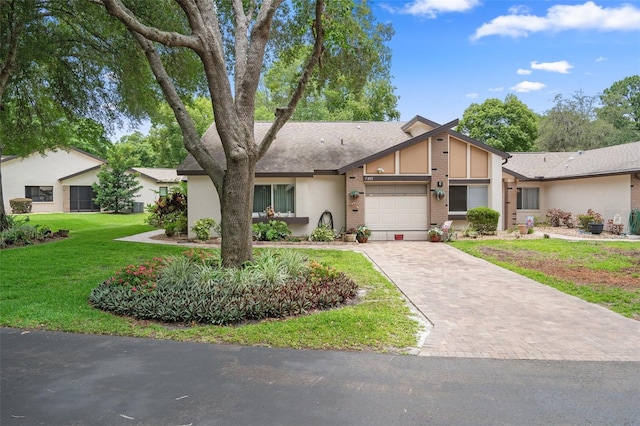 single story home featuring a garage and a front lawn