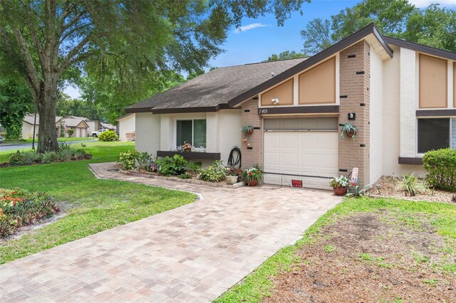 single story home with a garage and a front lawn