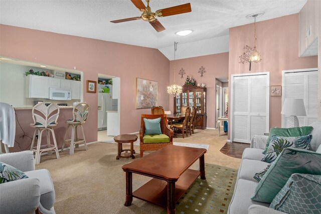 carpeted living room featuring ceiling fan with notable chandelier, lofted ceiling, and a textured ceiling