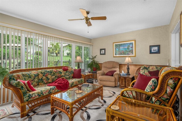 living room featuring ceiling fan and a textured ceiling