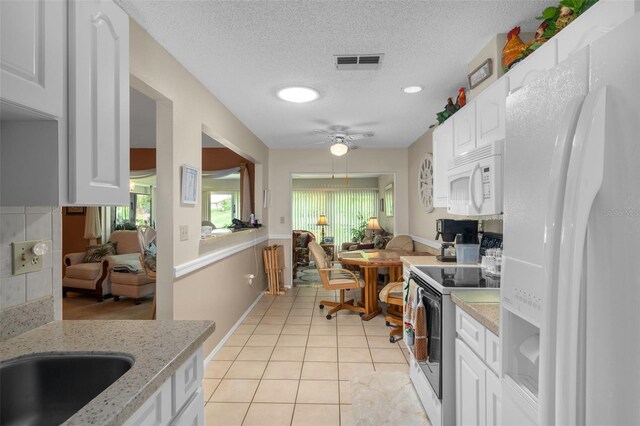 kitchen with ceiling fan, light tile patterned floors, white cabinets, and white appliances